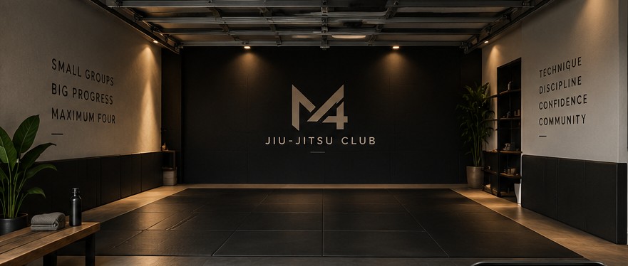 The M4 training space: dark mats under warm lighting with the M4 logo on the wall